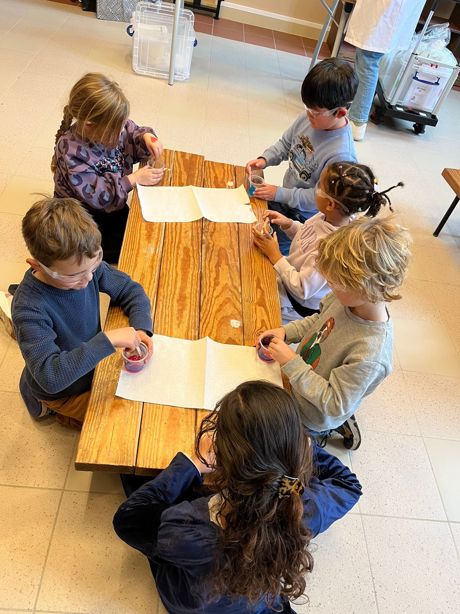 Kinderen met veiligheidsbril maken slijm. 