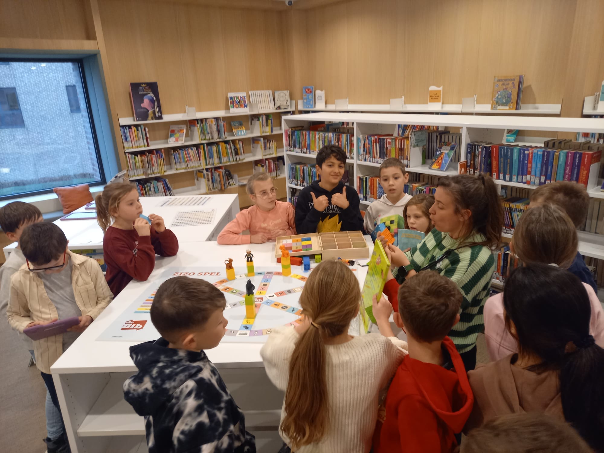 groep kinderen krijgen in de bibliotheek uitleg over een spel